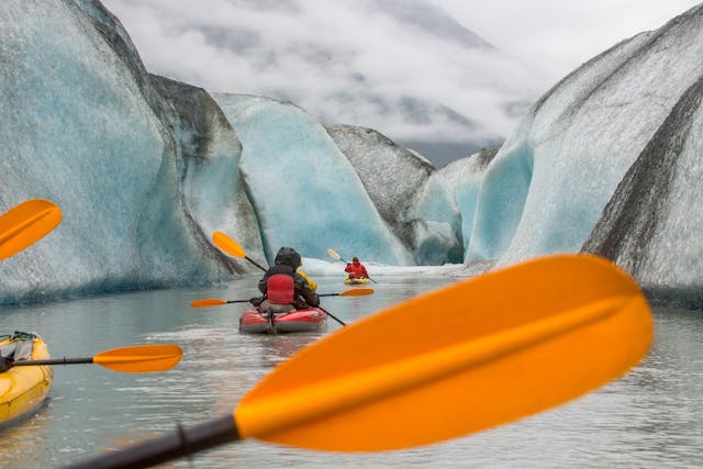 Kayakers paddling near glacier walls