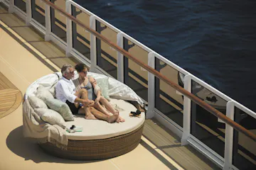 couple sitting on deck of Regent's Explorer ship