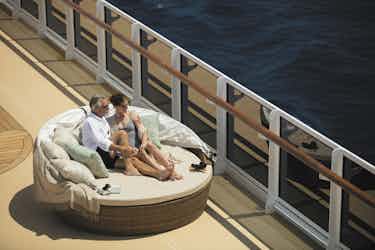 couple sitting on deck of Regent's Explorer ship