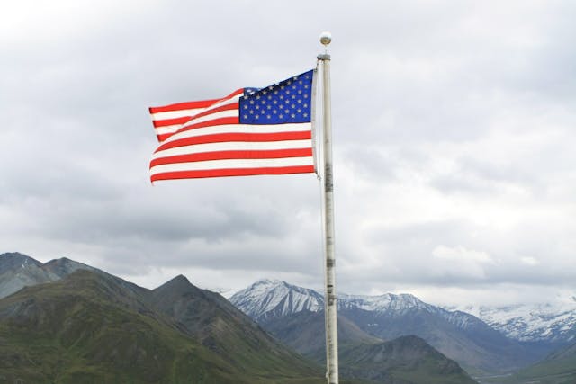 American flag on flagpole with mountains in background