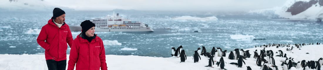 two people hiking in neko harbour, antarctica