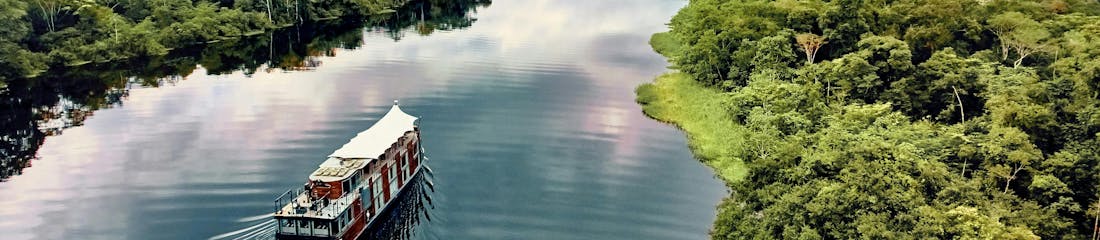 ship sailing in amazon - aqua expeditions