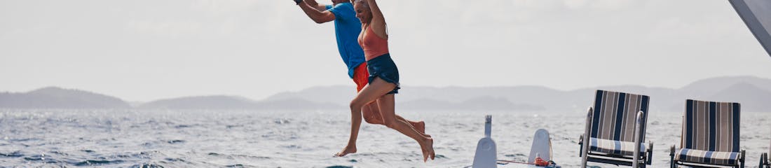 couple jumping off back of windstar ship - watersports