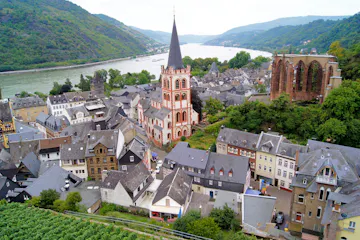 Riverside German town with slate roofs, tall red-and-white church spire and river bend