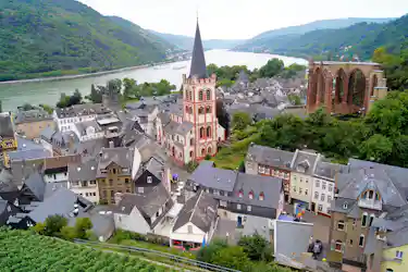 Riverside German town with slate roofs, tall red-and-white church spire and river bend
