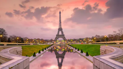 Eiffel Tower over Trocadéro reflecting pool at pink sunset, curved stone balustrades