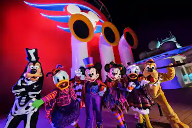 Mickey, Minnie, Donald, Daisy, Goofy and Pluto in Halloween costumes on a Disney cruise deck