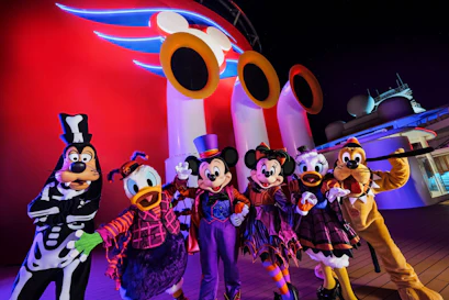 Mickey, Minnie, Donald, Daisy, Goofy and Pluto in Halloween costumes on a Disney cruise deck