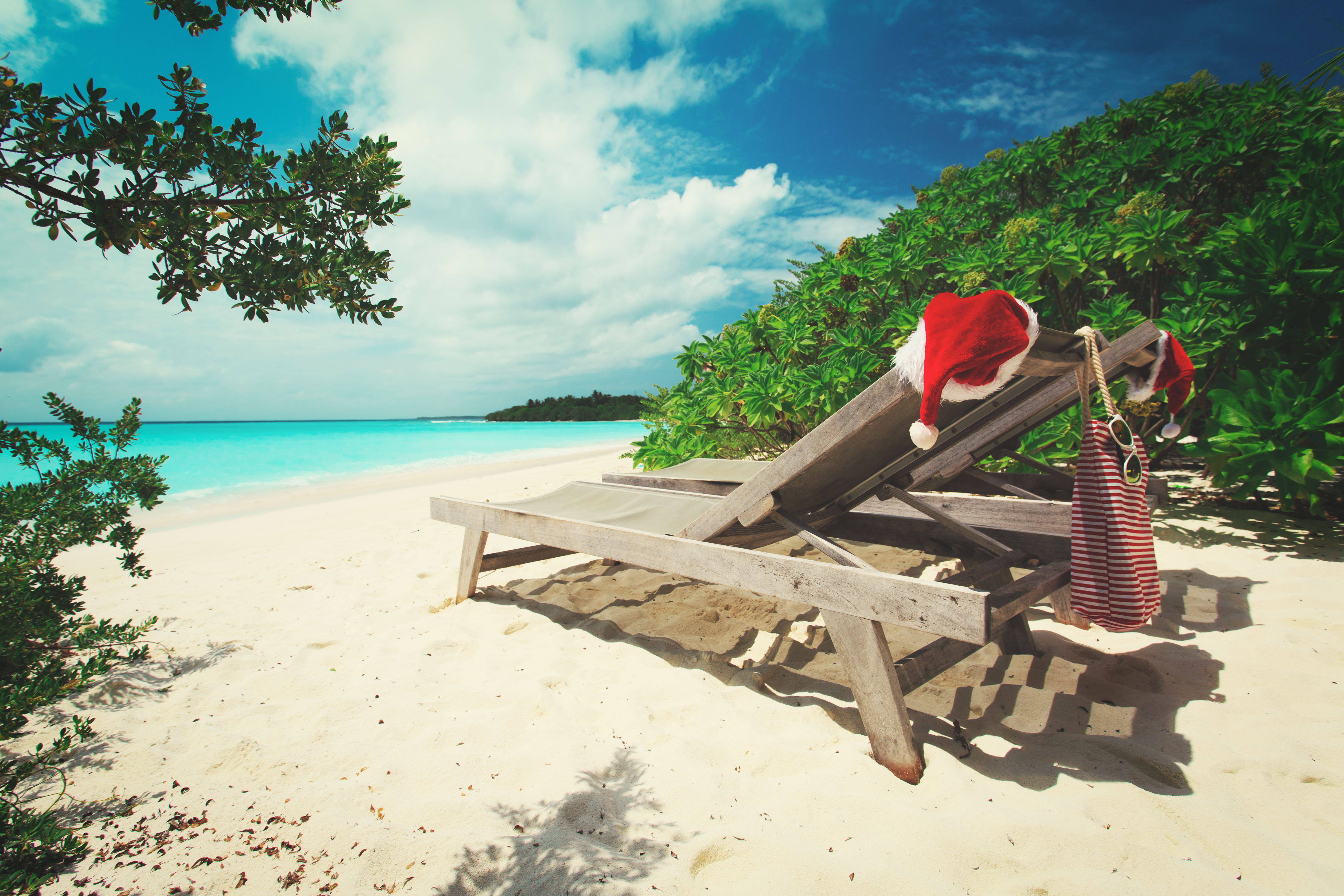 santa hats on chairs on the beach