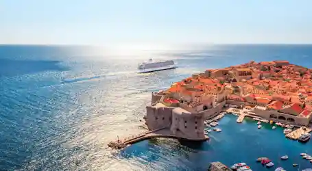 Aerial view of Dubrovnik's walled Old Town and harbor with cruise ship offshore
