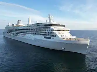 Silver Ray luxury cruise ship sailing on open sea, multiple balcony decks visible
