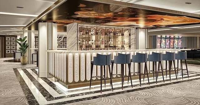 Upscale casino bar with marble island, blue barstools, patterned carpet, and slot machines