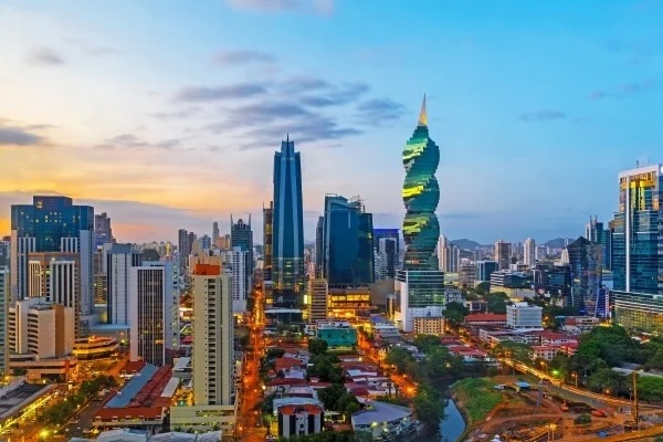 Panama City skyline at sunset with twisted F&F Tower and illuminated downtown streets.