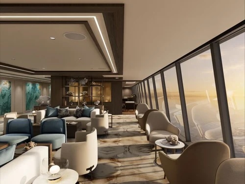 Sunset lounge with ocean view: floor-to-ceiling windows, curved armchairs, sofas, small tables.