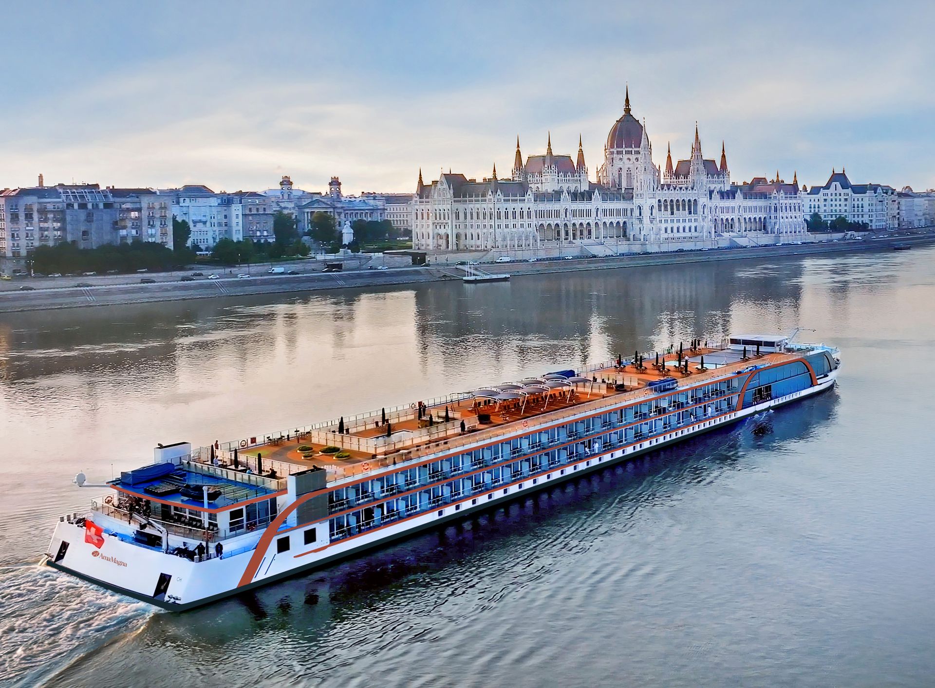 River cruise ship passing the Hungarian Parliament building on the Danube at dusk