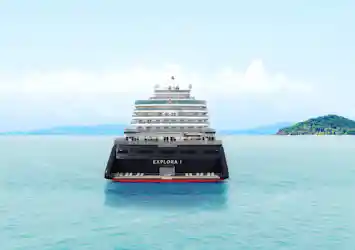 Rear view of cruise ship Explora I centered on turquoise sea with distant islands