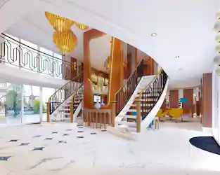 Grand foyer with twin staircases, brass chandeliers, marble floors and river views