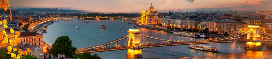 Budapest dusk panorama: illuminated Chain Bridge over the Danube and lit Parliament, crescent moon