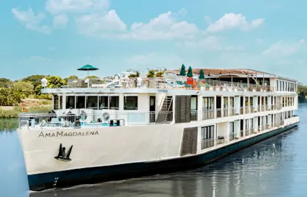 White river cruise ship AmaMagdalena on calm water with open upper deck and waterside greenery