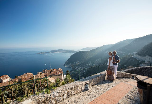 Couple on flagstone path looking out over rooftops to the ocean